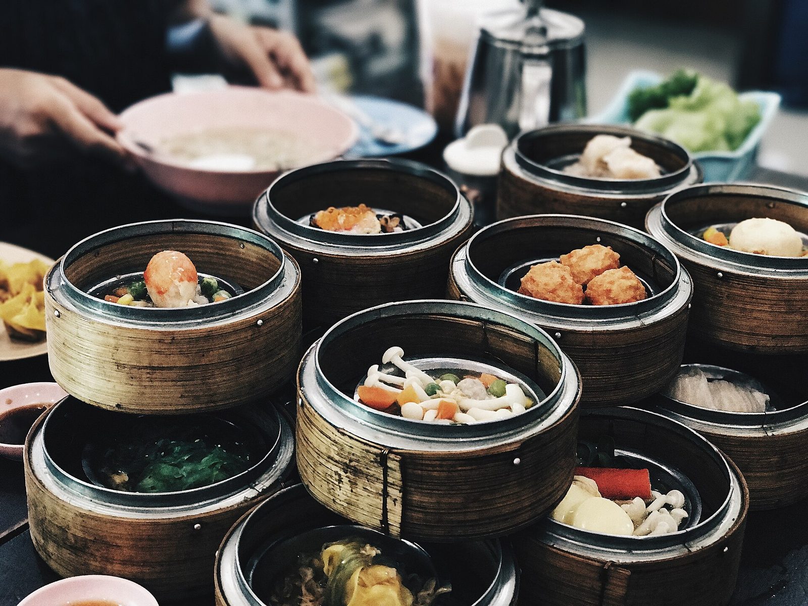 Bamboo steamers of dim sum being served at a table